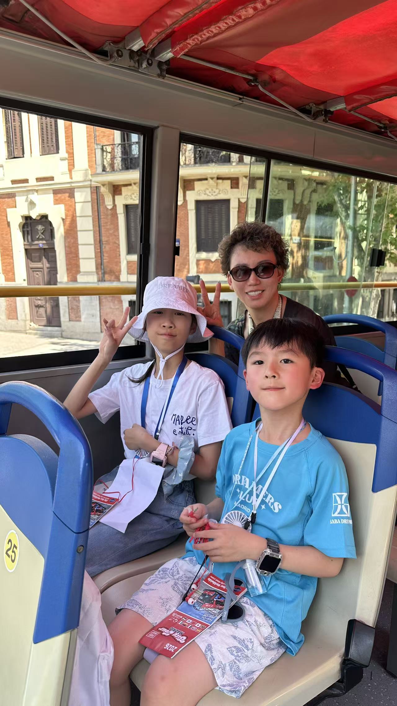 Children and an accompanying adult smiling on the Madrid tour bus